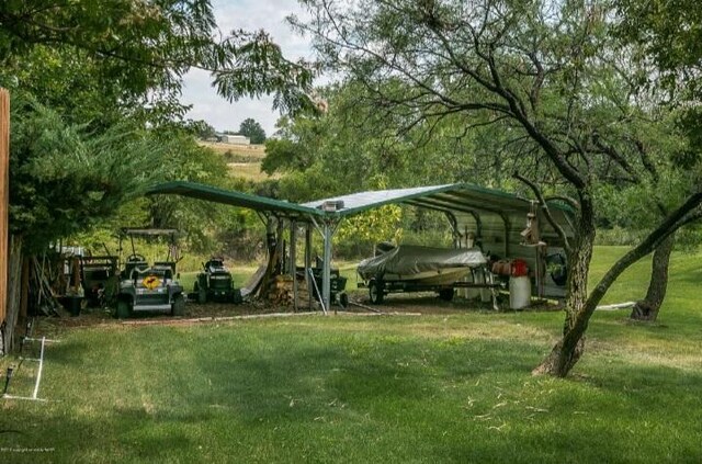 view of parking featuring a carport and a yard