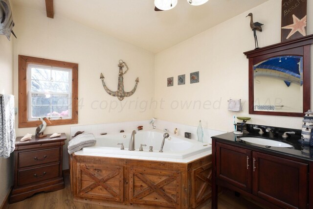 bathroom featuring a washtub, vanity, hardwood / wood-style floors, and vaulted ceiling with beams