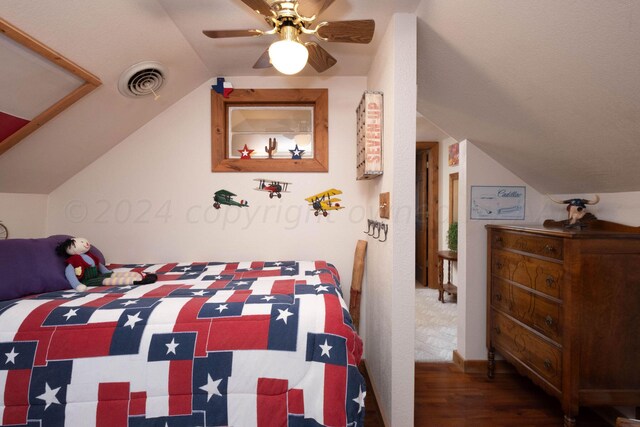 bedroom featuring dark wood-type flooring, vaulted ceiling, and ceiling fan