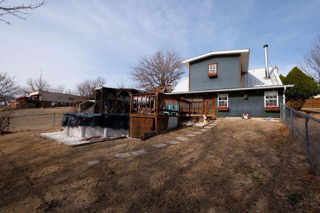 rear view of property featuring a wooden deck