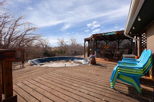 wooden terrace featuring a covered pool and a pergola