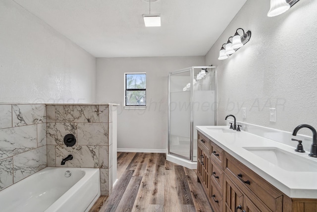517 Whittier St, Hereford, TX 79045 - bathroom with wood finished floors, a stall shower, a bath, and double vanity