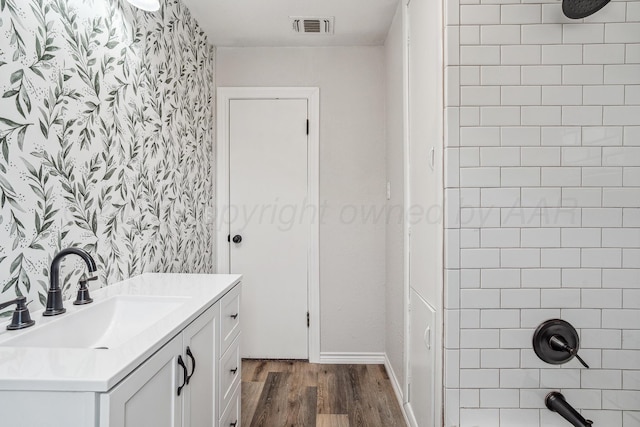 517 Whittier St, Hereford, TX 79045 - bathroom with wallpapered walls, wood finished floors, vanity, and shower / washtub combination