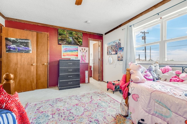 bedroom with light colored carpet, a ceiling fan, and a textured ceiling