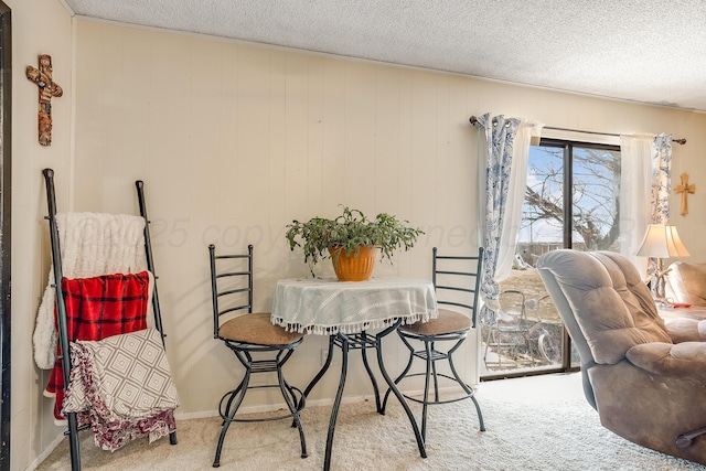 dining space with carpet floors and a textured ceiling