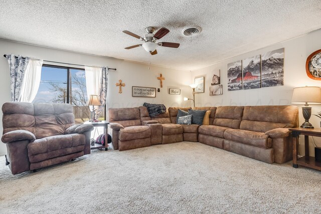 living room featuring visible vents, carpet flooring, a textured ceiling, and ceiling fan