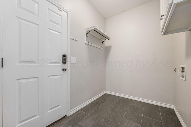 laundry area featuring baseboards and cabinet space