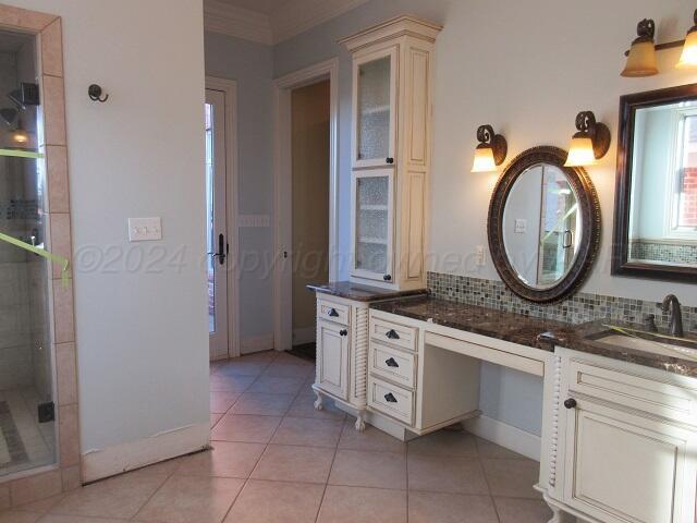 bathroom with crown molding, tasteful backsplash, tile patterned flooring, and vanity