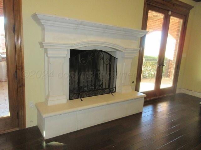 interior details with french doors, a fireplace, and wood-type flooring