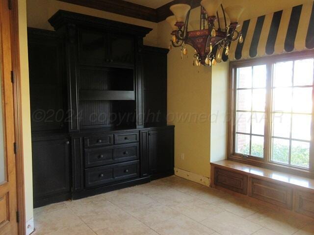 interior space with ornamental molding, a chandelier, and light tile patterned flooring