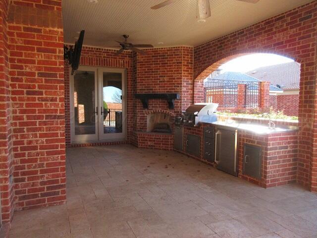 view of patio / terrace with ceiling fan, exterior kitchen, and area for grilling