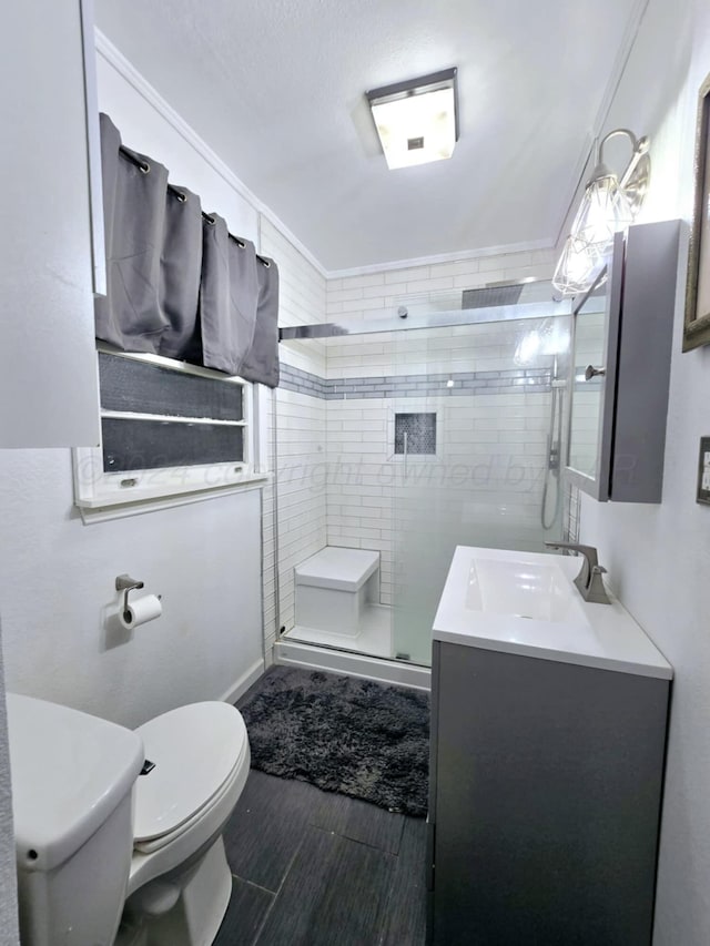 bathroom featuring vanity, toilet, and a shower with shower door