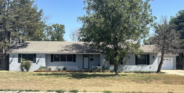 ranch-style house featuring a front lawn and a garage