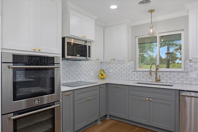 4400 Gem Lake Rd, Amarillo, TX 79106 - kitchen featuring gray cabinets, appliances with stainless steel finishes, light countertops, crown molding, and tasteful backsplash