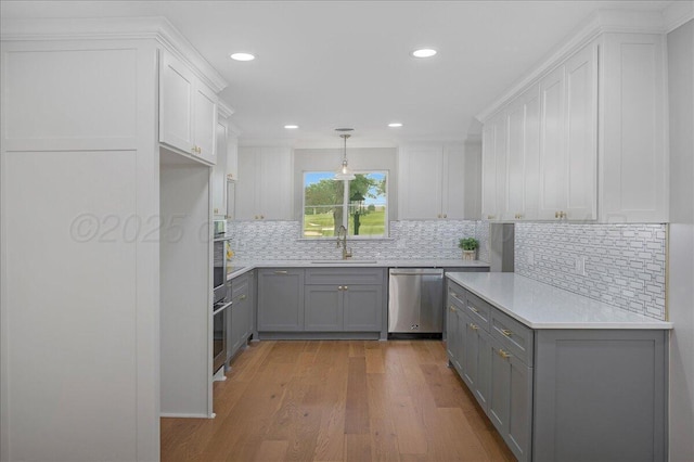 4400 Gem Lake Rd, Amarillo, TX 79106 - kitchen with stainless steel appliances, gray cabinetry, light countertops, light wood-type flooring, and recessed lighting