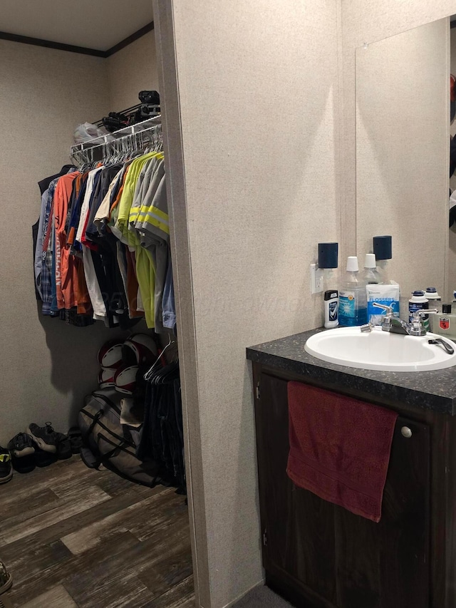 bathroom featuring hardwood / wood-style flooring, vanity, and crown molding