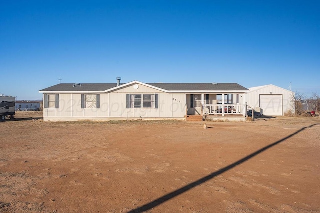 back of house with a porch, a garage, and an outdoor structure