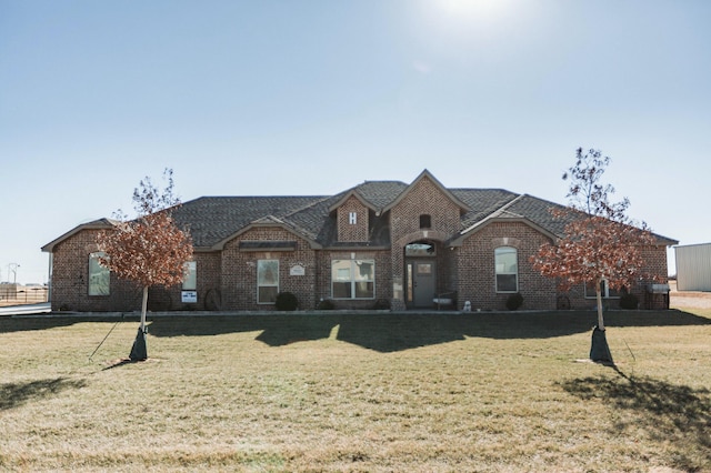 french country inspired facade featuring a front lawn