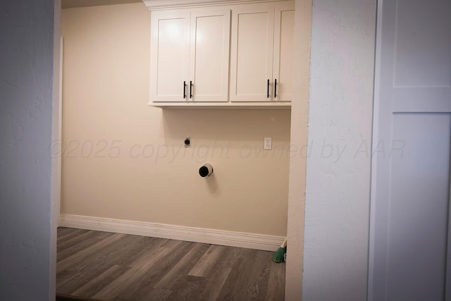 laundry room with electric dryer hookup, dark hardwood / wood-style flooring, and cabinets