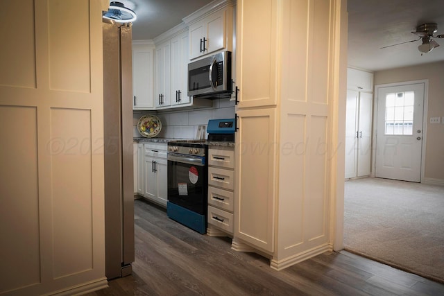 kitchen featuring dark hardwood / wood-style floors, tasteful backsplash, white cabinetry, ceiling fan, and stainless steel appliances