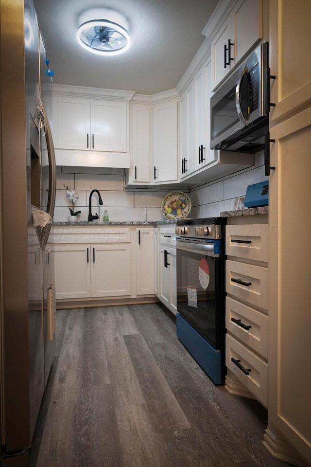 kitchen featuring tasteful backsplash, dark hardwood / wood-style floors, white cabinets, and appliances with stainless steel finishes