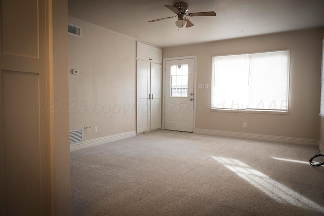 empty room featuring ceiling fan and carpet
