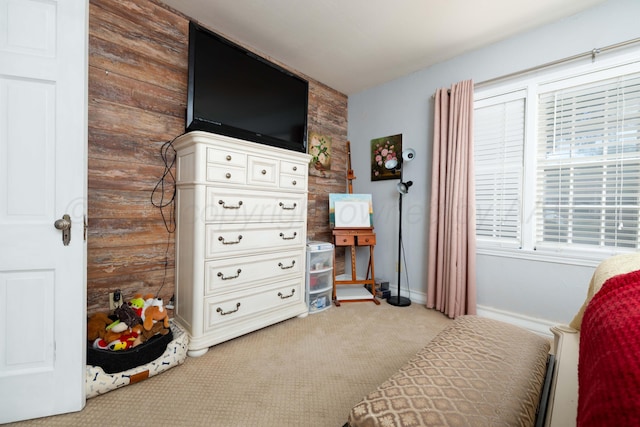 carpeted bedroom featuring wooden walls