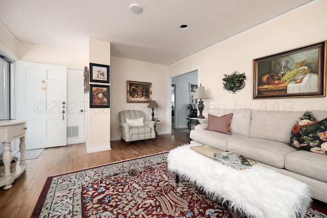 living room featuring hardwood / wood-style flooring and baseboards