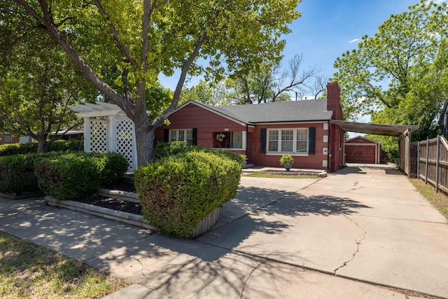 ranch-style home featuring a carport, driveway, and a chimney