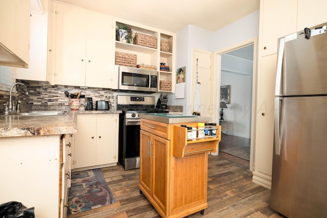 kitchen with stainless steel appliances, a sink, dark wood-type flooring, open shelves, and tasteful backsplash