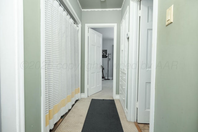 hall with baseboards and light colored carpet