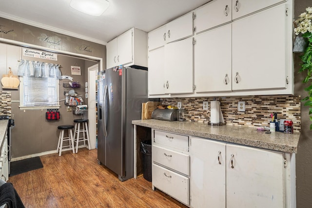 3616 NE 21st Ave, Amarillo, TX 79107 - kitchen featuring stainless steel fridge with ice dispenser, white cabinetry, decorative backsplash, and wood finished floors