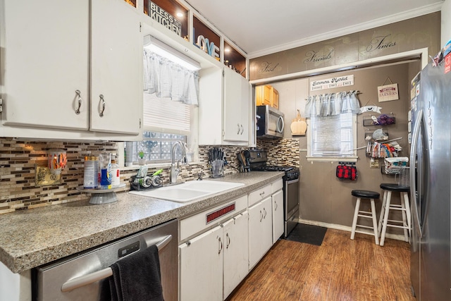 3616 NE 21st Ave, Amarillo, TX 79107 - kitchen featuring appliances with stainless steel finishes, white cabinetry, ornamental molding, and backsplash
