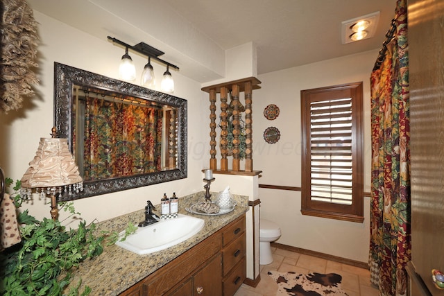 4410 Chandler Dr, Amarillo, TX 79109 - bathroom with vanity, toilet, baseboards, and tile patterned flooring