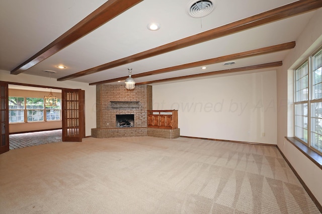 4410 Chandler Dr, Amarillo, TX 79109 - unfurnished living room featuring carpet, beam ceiling, plenty of natural light, a brick fireplace, and a chandelier
