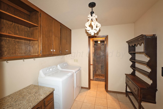 4410 Chandler Dr, Amarillo, TX 79109 - washroom featuring separate washer and dryer, cabinet space, light tile patterned flooring, a chandelier, and baseboards