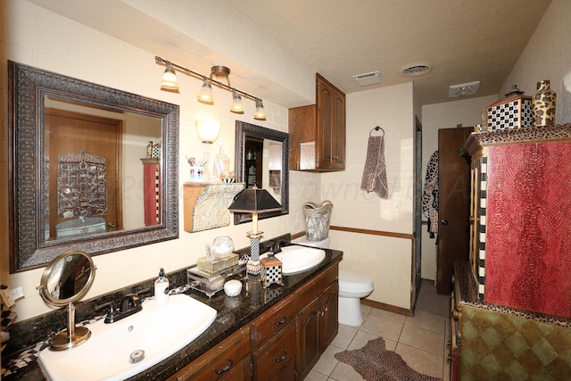 4410 Chandler Dr, Amarillo, TX 79109 - bathroom with double vanity, tile patterned floors, toilet, and tile walls