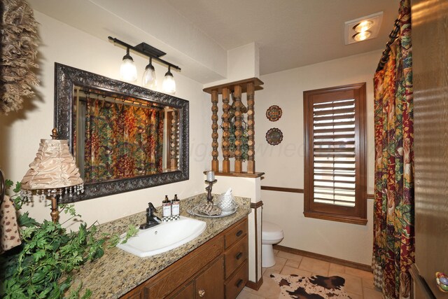 4410 Chandler Dr, Amarillo, TX 79109 - full bath with vanity, toilet, baseboards, and tile patterned floors