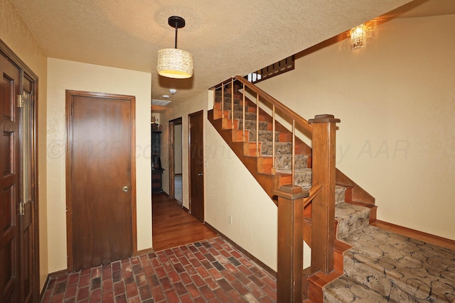 4410 Chandler Dr, Amarillo, TX 79109 - stairs with a textured ceiling and brick floors