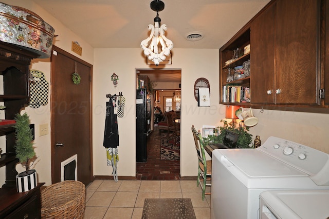 4410 Chandler Dr, Amarillo, TX 79109 - laundry area featuring washer and dryer, cabinet space, light tile patterned floors, a chandelier, and baseboards