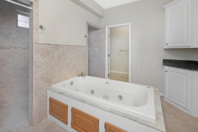 13701 Cedarwood Dr, Amarillo, TX 79118 - bathroom with a tub with jets, tile walls, and tile patterned floors