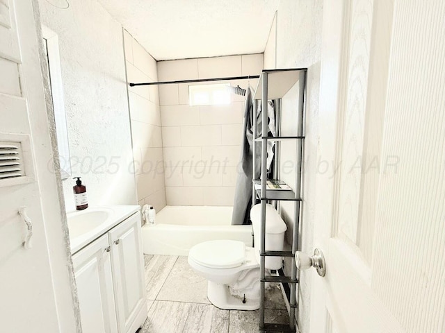 full bathroom with vanity, tiled shower / bath, and toilet