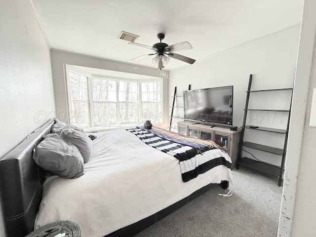 carpeted bedroom featuring ornamental molding and ceiling fan