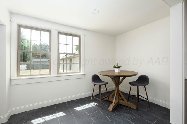 dining space with dark tile patterned flooring