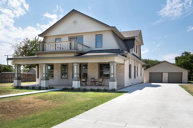 view of front of home with a porch, a balcony, a front lawn, a garage, and an outdoor structure