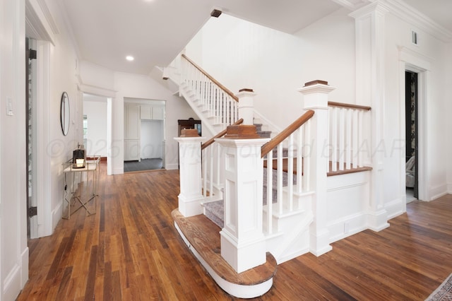 stairs with hardwood / wood-style floors and crown molding