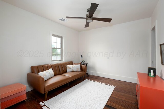 living room featuring ceiling fan and dark wood-type flooring