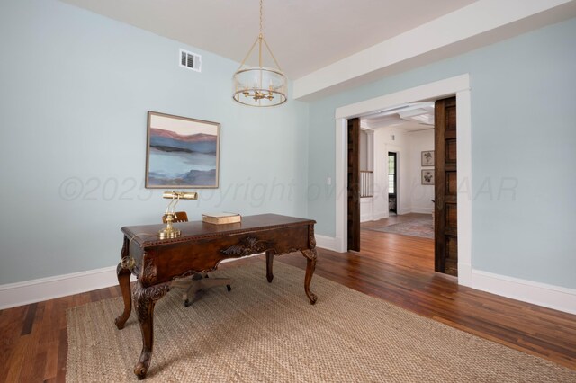 office space with a notable chandelier and dark hardwood / wood-style floors