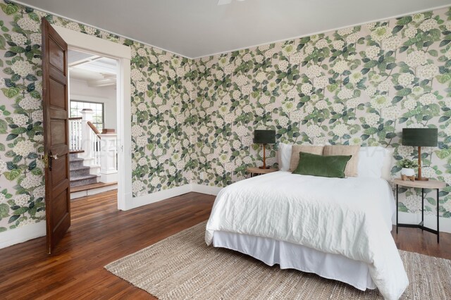 bedroom with dark hardwood / wood-style flooring and ornamental molding