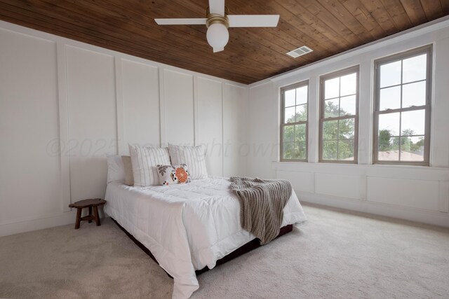 bedroom with ceiling fan, crown molding, light colored carpet, and wooden ceiling